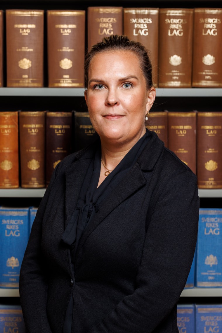 Angelica Bergström, porträtt framför hyllor med lagböcker.